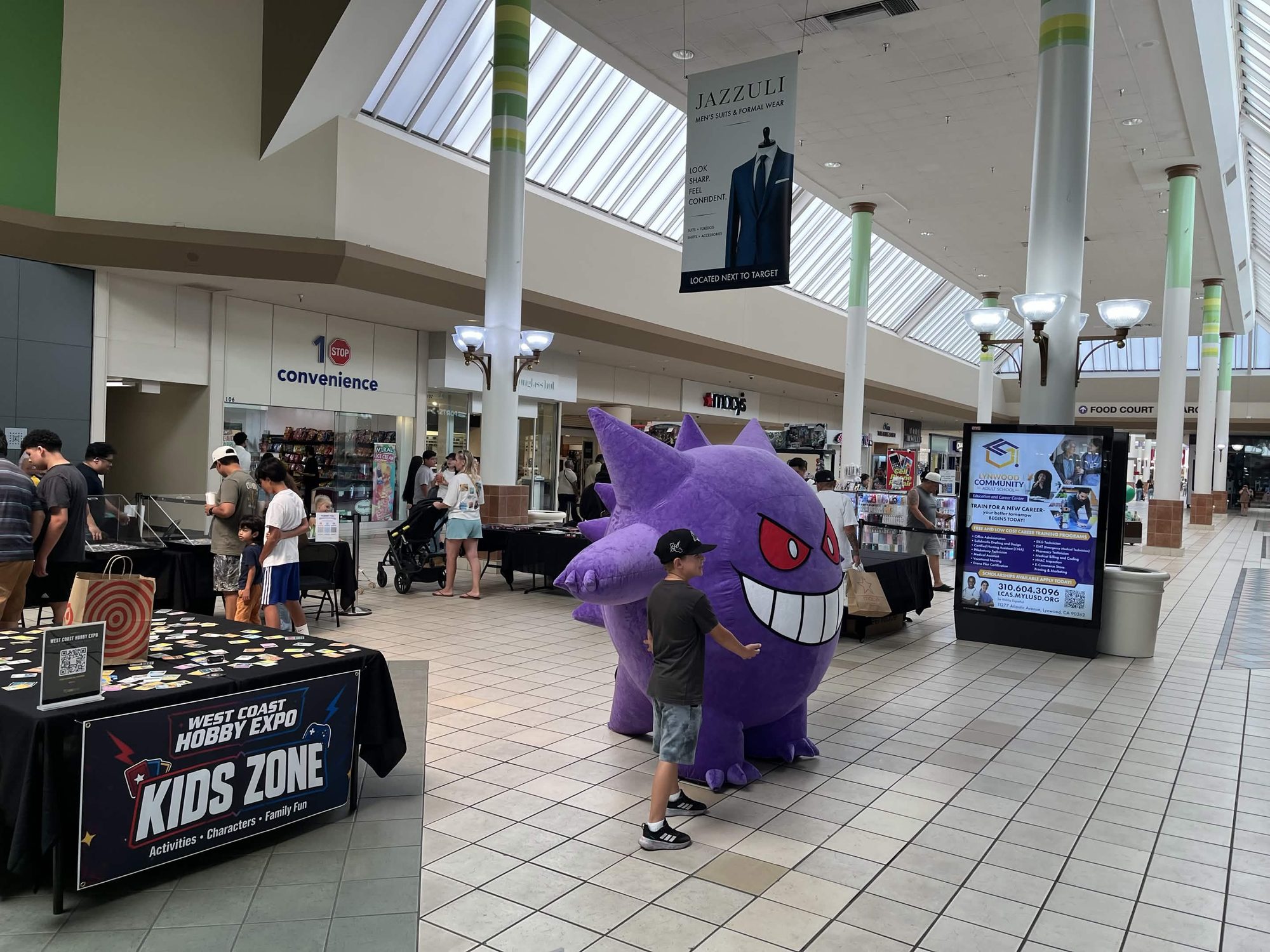 Kid with giant Gengar inflatable next to the Kids Zone table